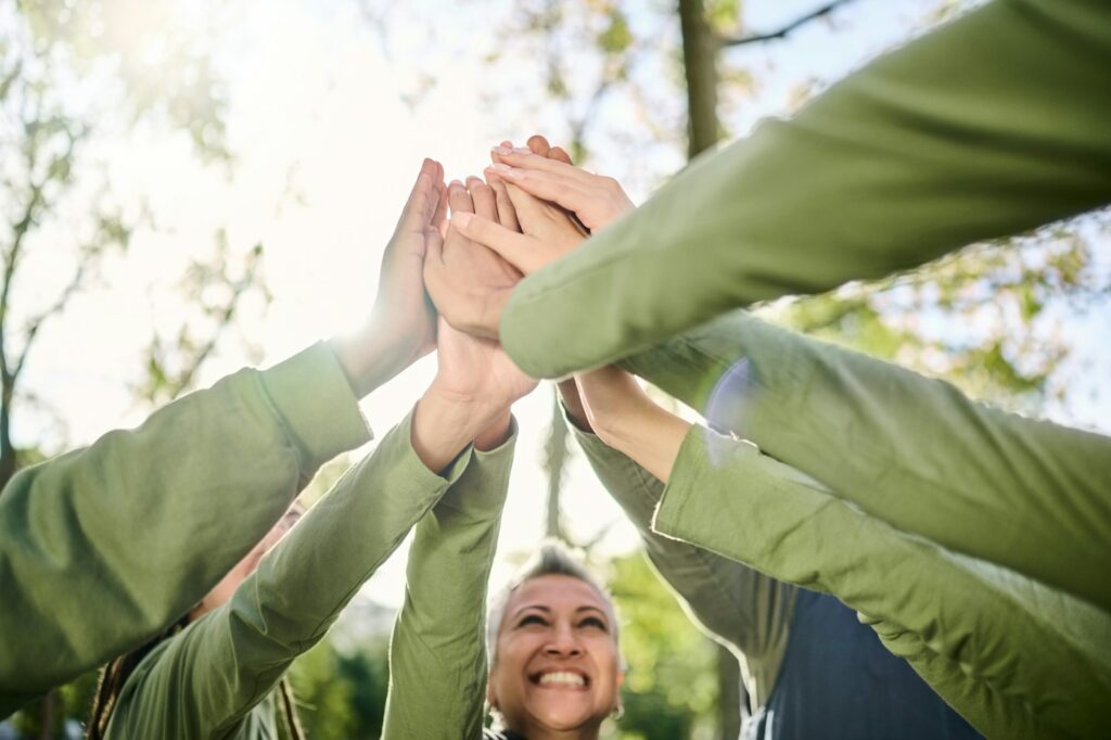 High five, outdoor and hands from team building at a wellness retreat with community and support. V